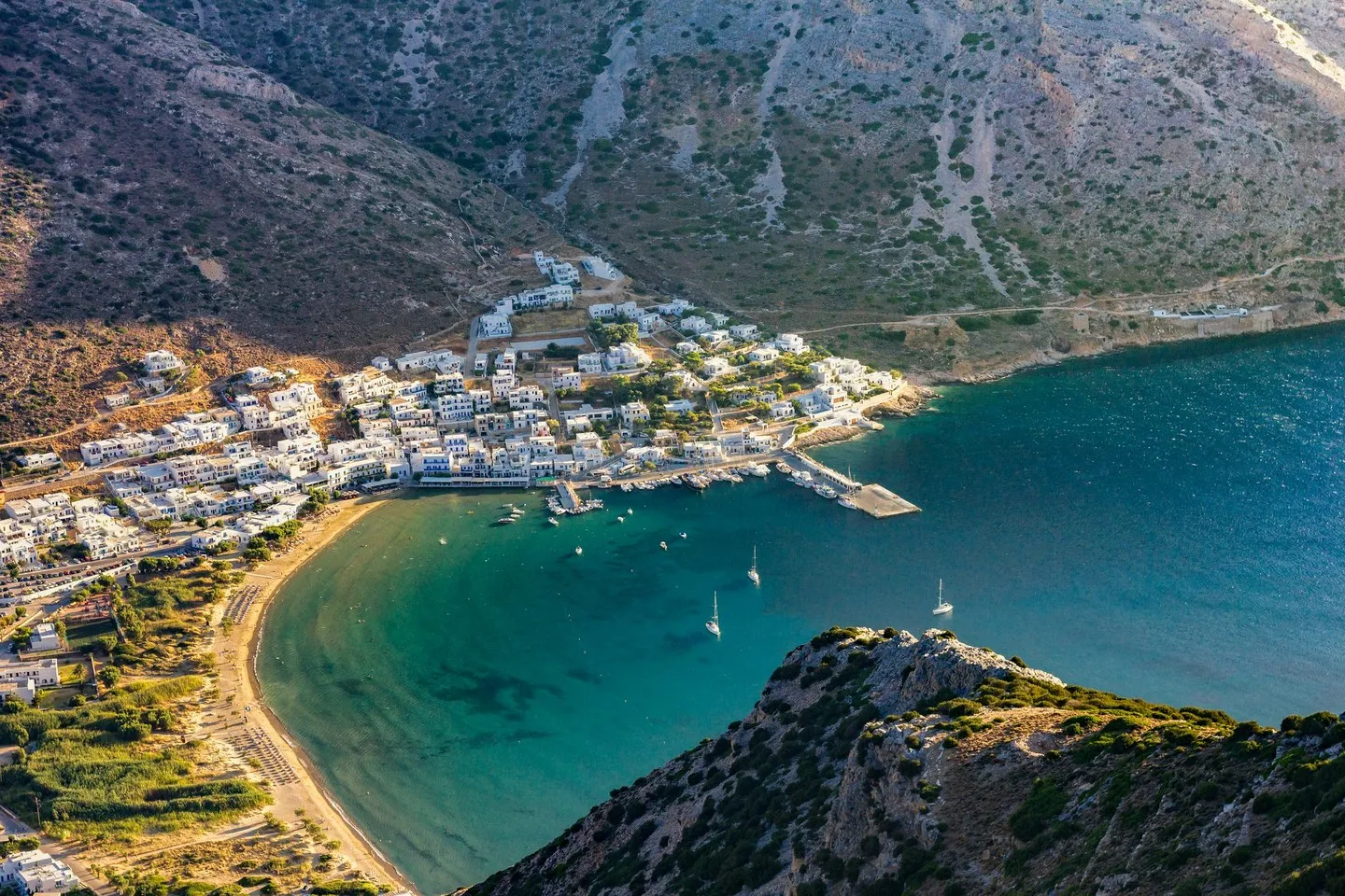 Kamares on Sifnos seen from above, white houses along a sandy bay below bare mountains